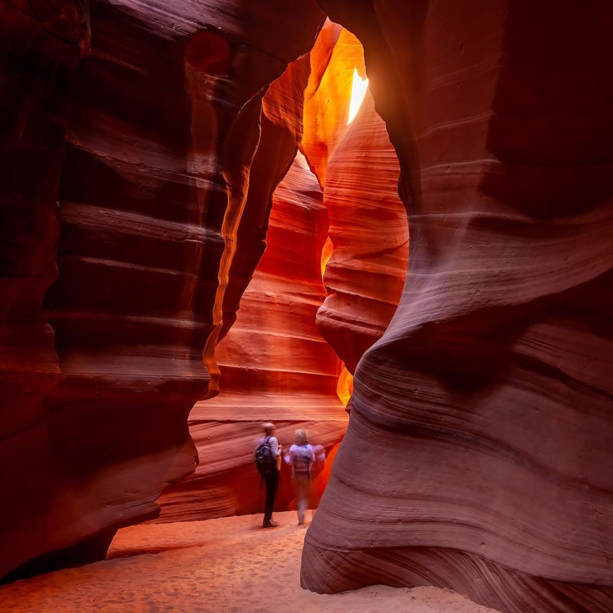two people walking through antelope canyon